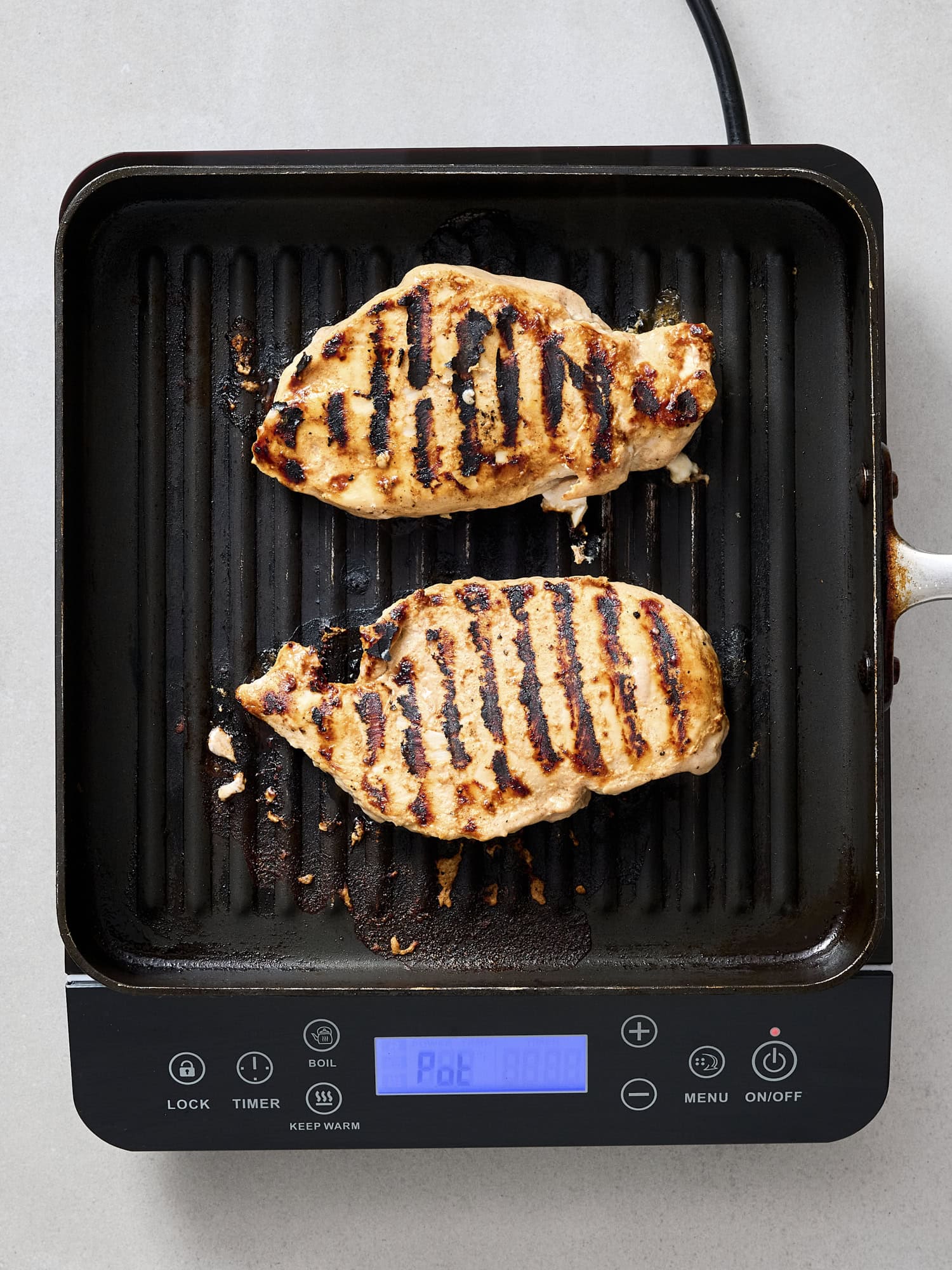 Chicken breast on grill with grill marks.
