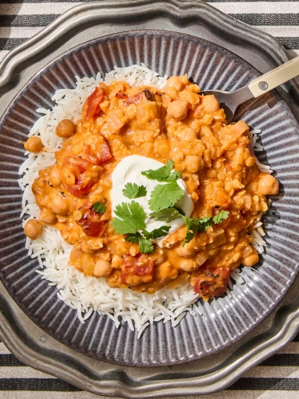 Plate with lentil and chickpea curry on top of rice.