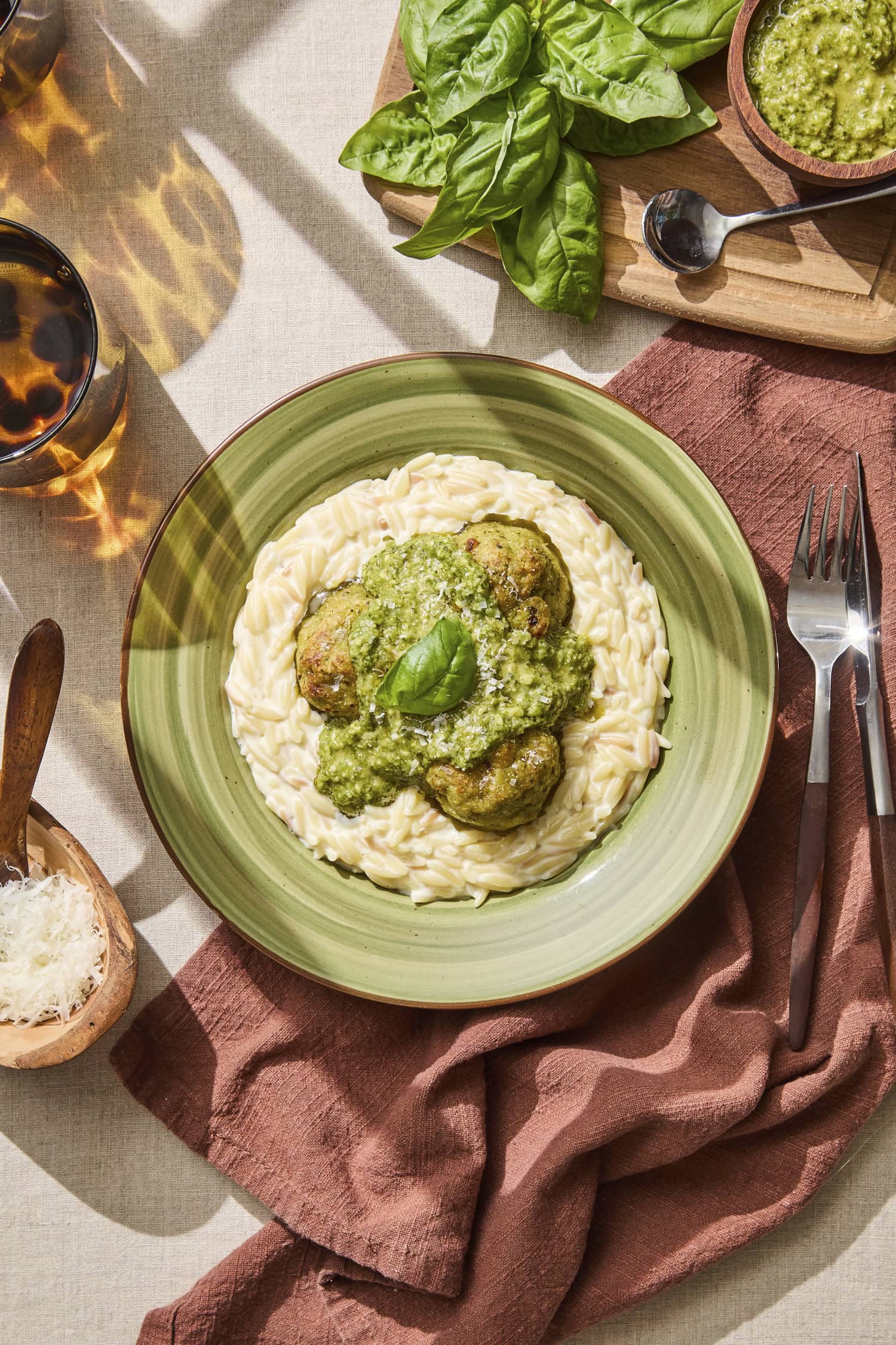Bowl with creamy orzo and pesto chicken meatballs on top.