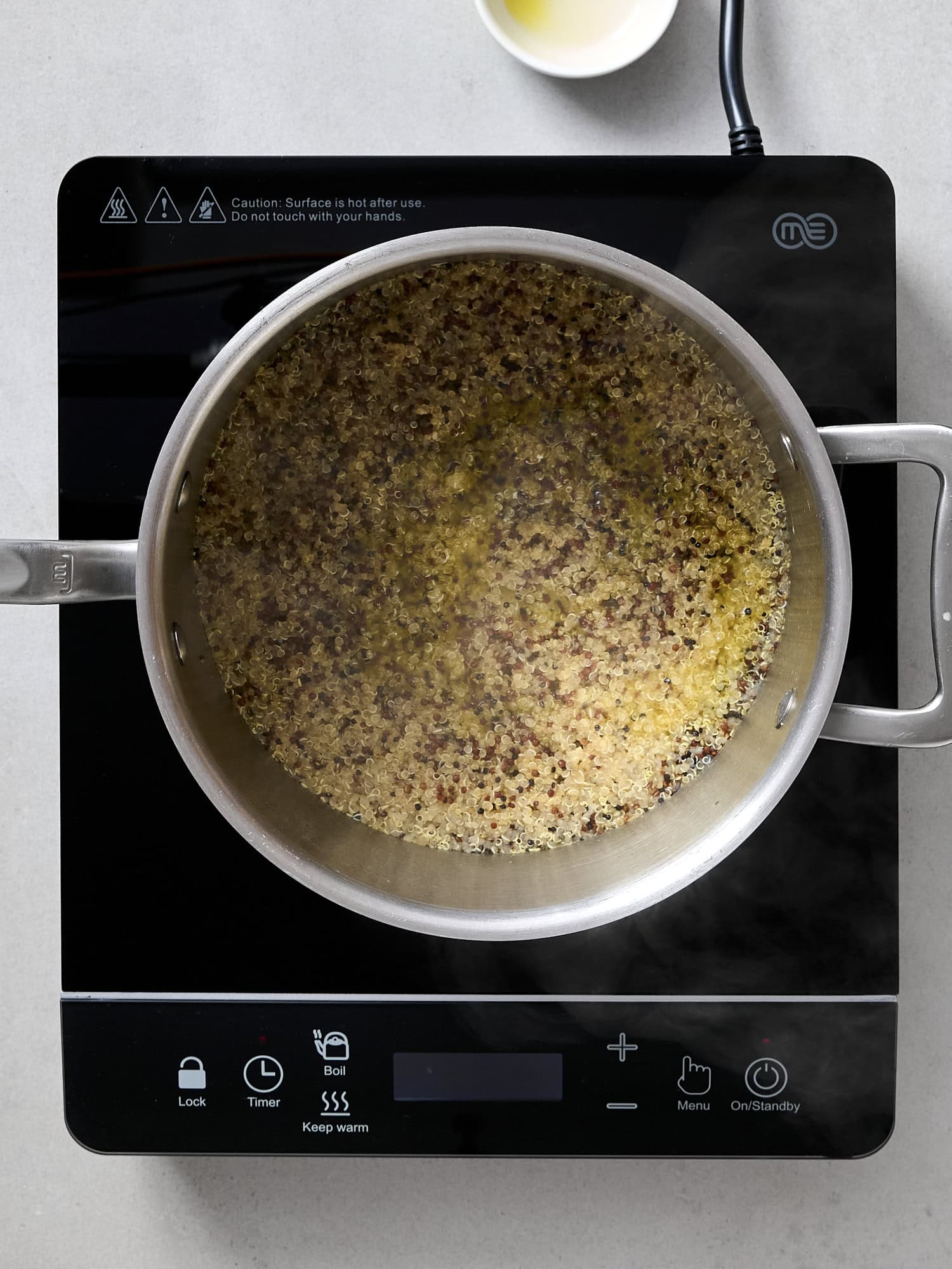 Quinoa cooked in chicken stock in pan.